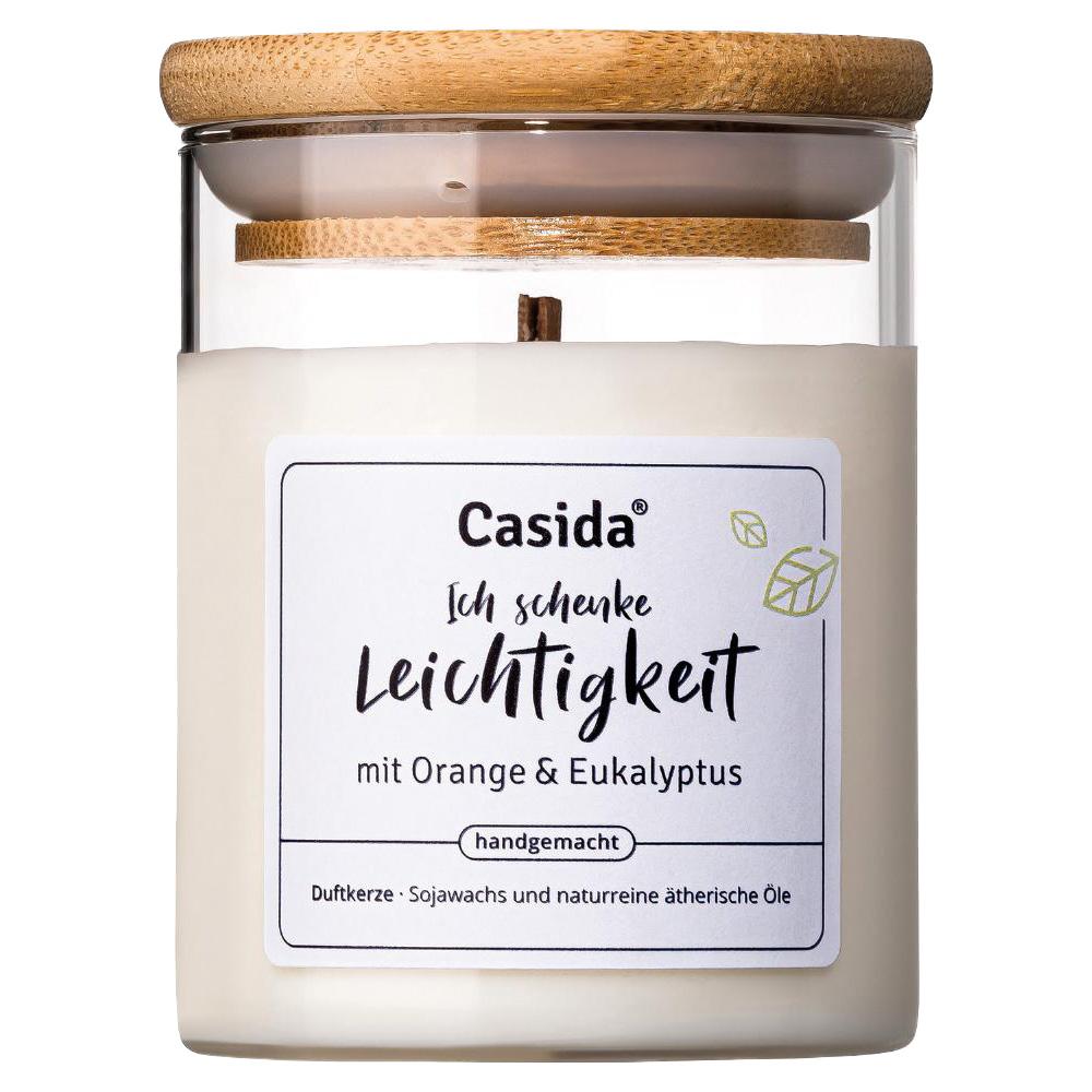 Eine wei&szlig;e Duftkerze mit Holzdeckel und Etikett "Leichtigkeit" aus Sojawachs.